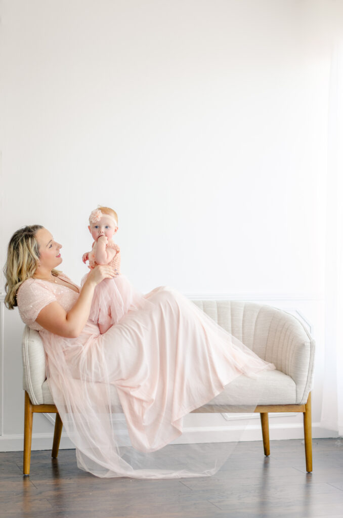 moeder en baby in roze jurk voor een fotoshoot