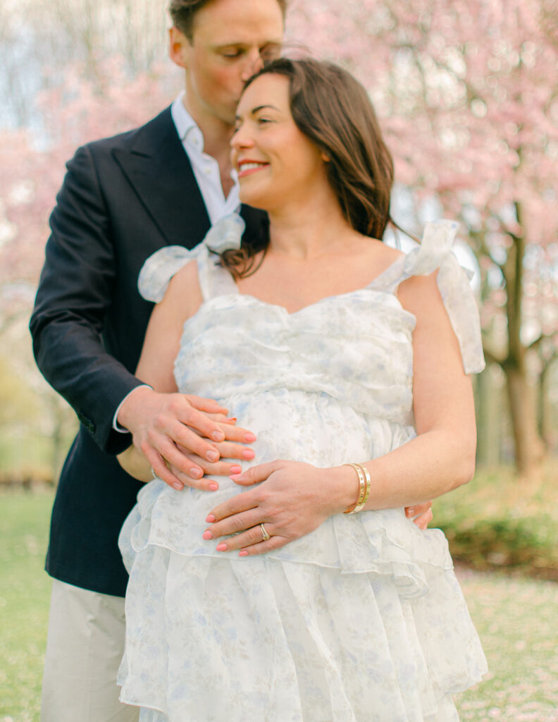 Close up detail of husband's hands on expecting mother's baby bump. 