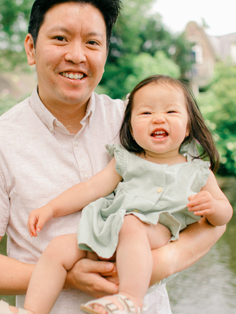 Father and daughter smile big silly grins during a Giethoorn photoshoot.