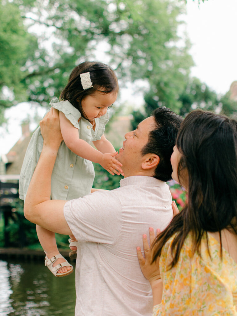 Toddler daughter reaches out to grab father's face.