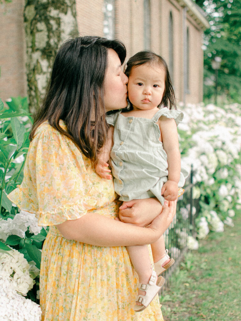 Mom gives daughter a kiss on the cheek.