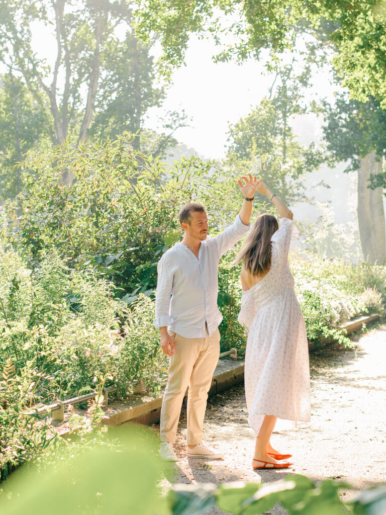 Husband twirls pregnant wife in the Miracle Garden.