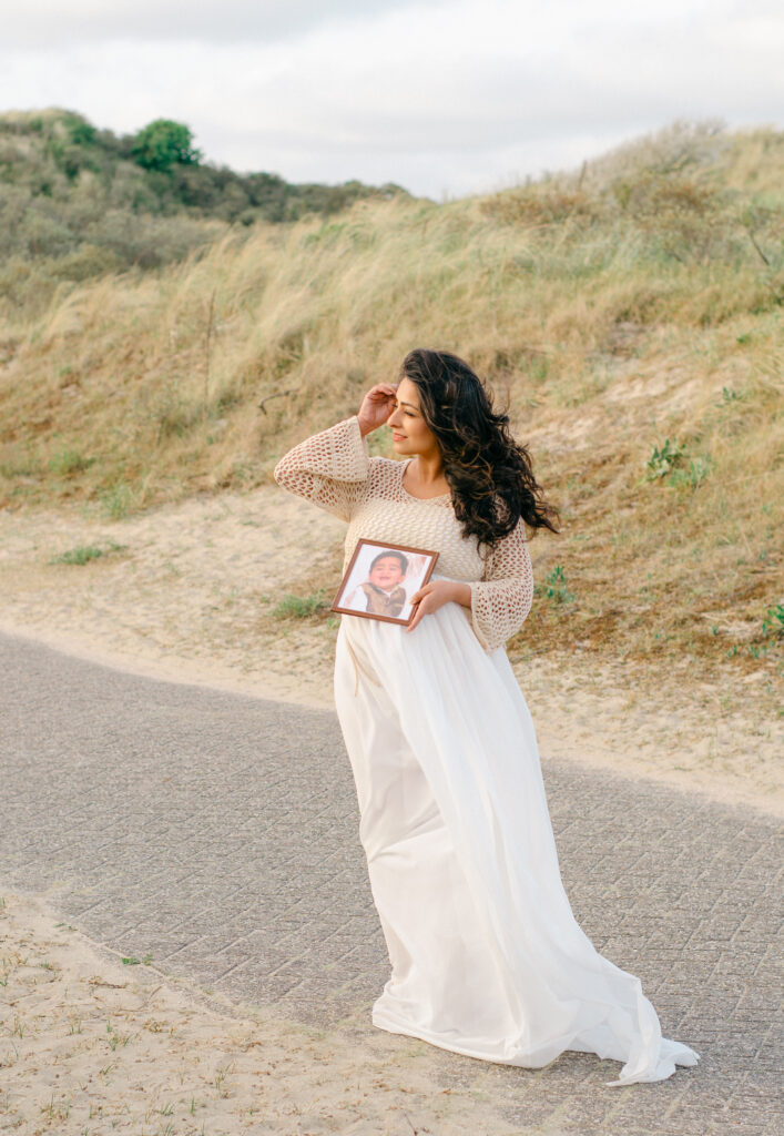 Expecting mother holds the photo of her firstborn son, who passed away. 