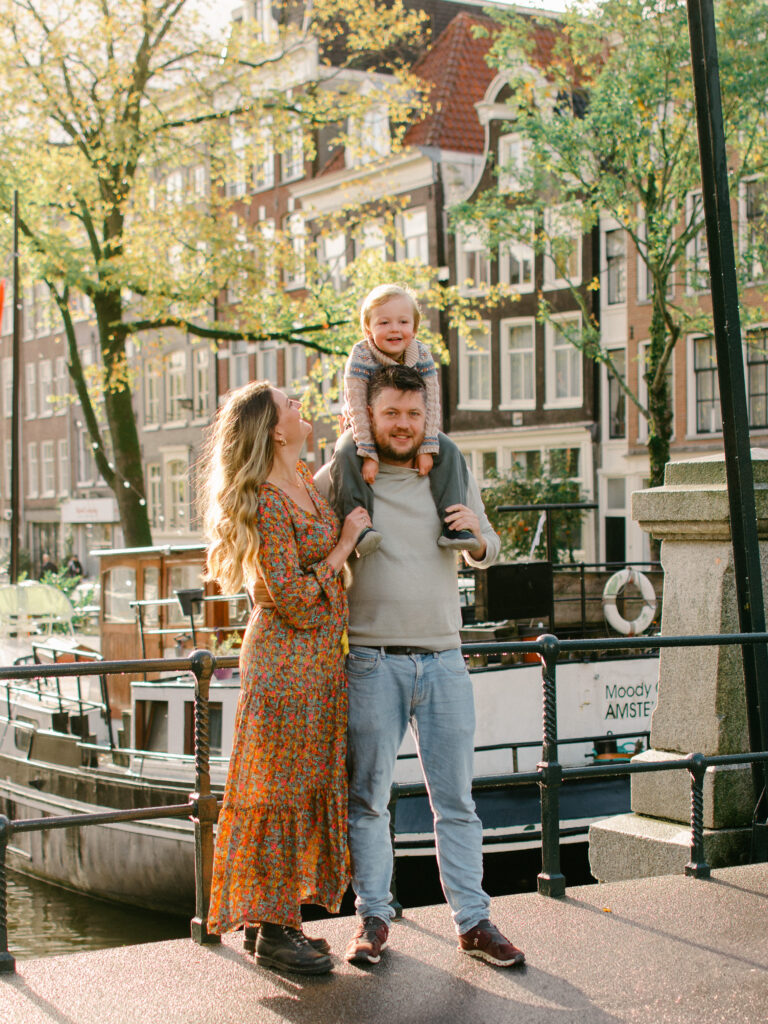 Lifestyle session with little boy on his father's shoulders with mum looking up at him.