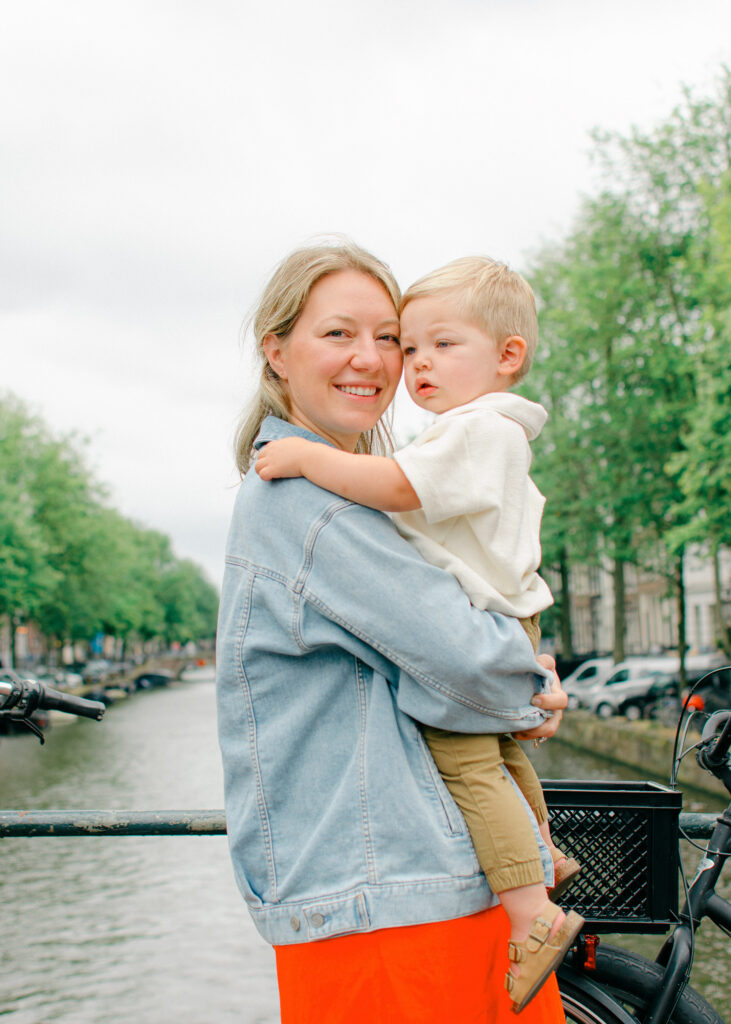 Mom holds son on an Amsterdam bridge in the Amsterdam Nine Streets.