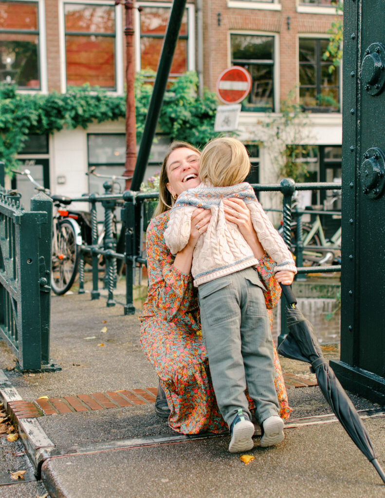Little boy runs to his mum who gives him a big hug in the Jordaan district.