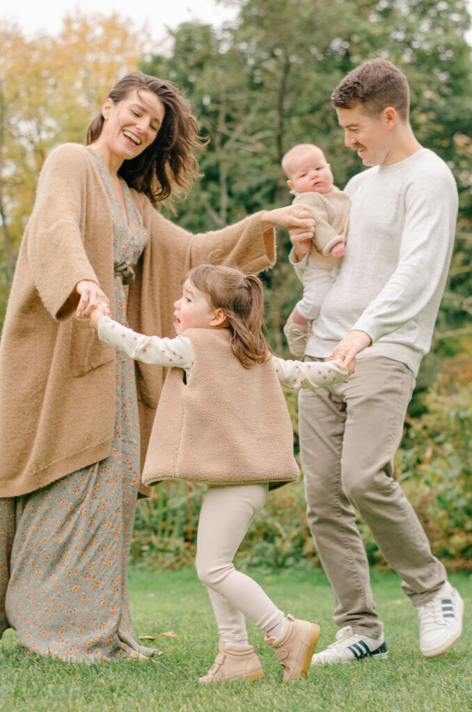 Family of four spins around in Vondelpark in the fall.