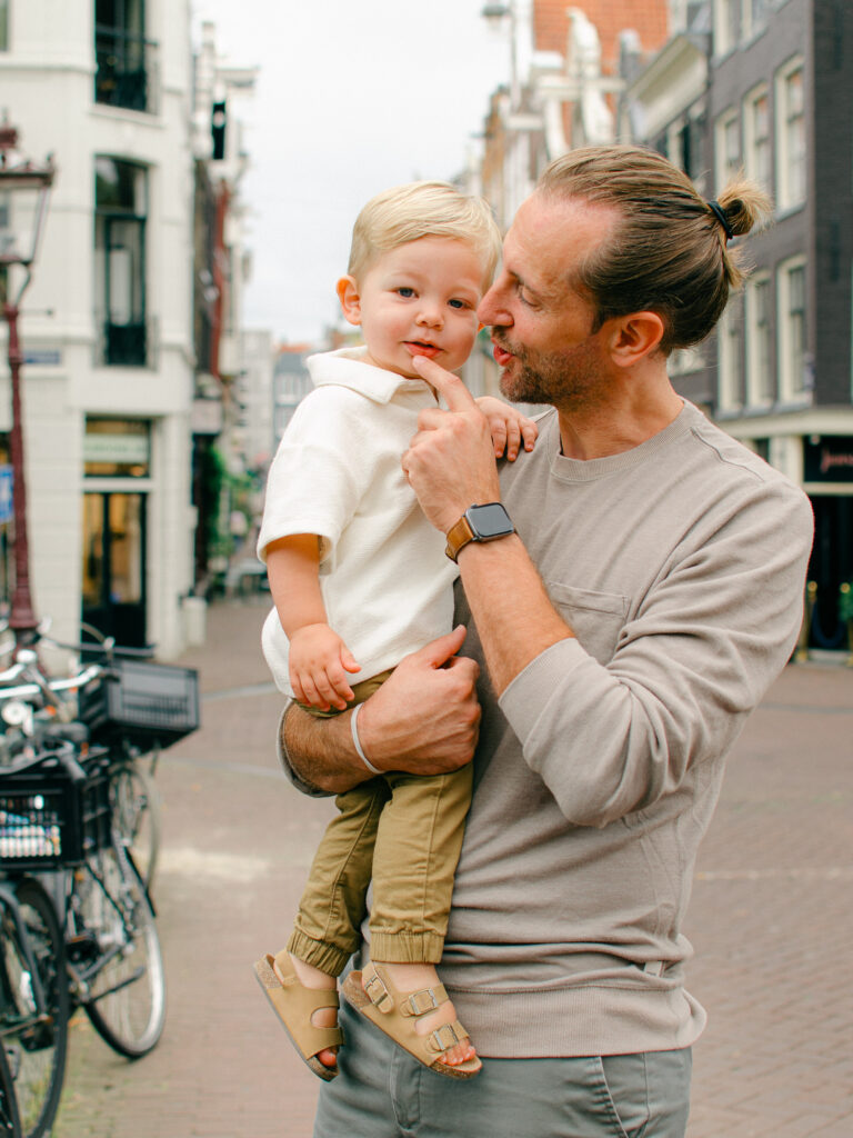 Dad tries to make his son laugh while on a walk in the Amsterdam Nine Streets.
