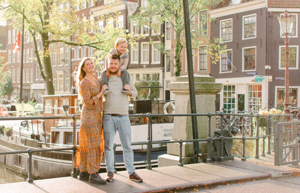 Horizontal image of a family on a bridge in Amsterdam.