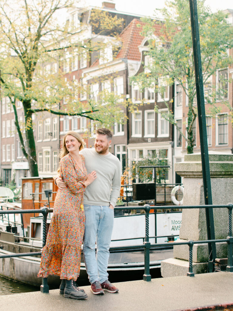 Couple smiles and watches their son run to them near an Amsterdam canal.