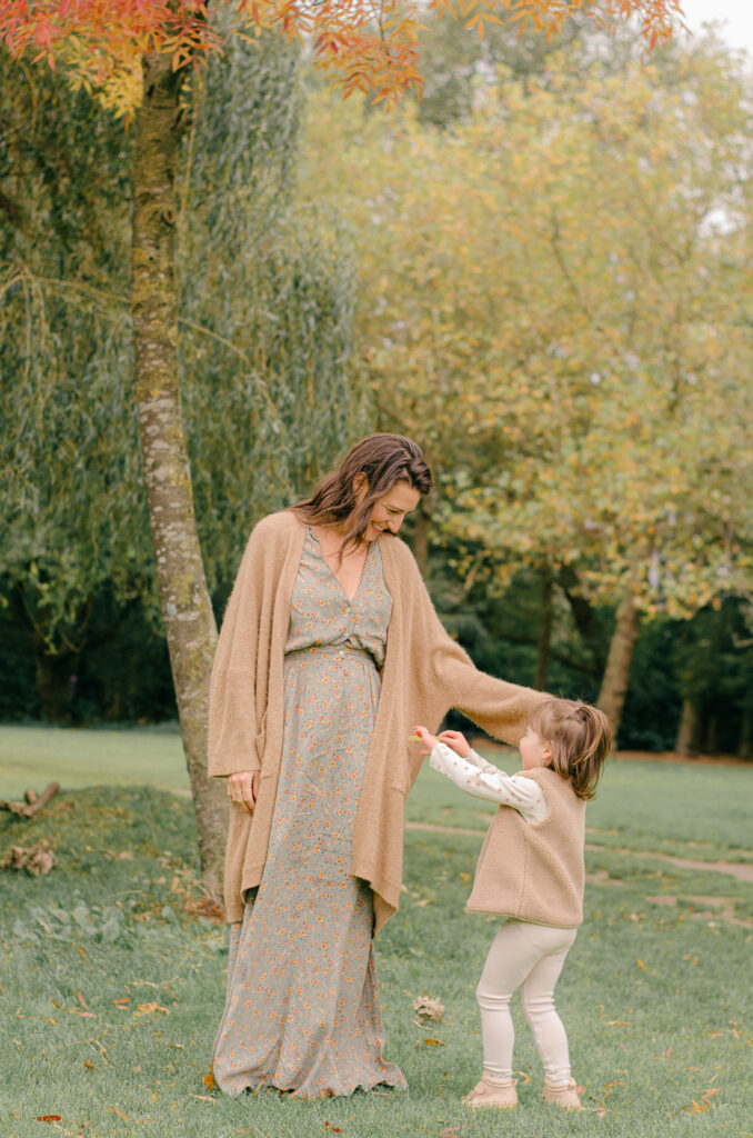 Mother brushes daughter's hair back in a candid moment in Vondelpark.