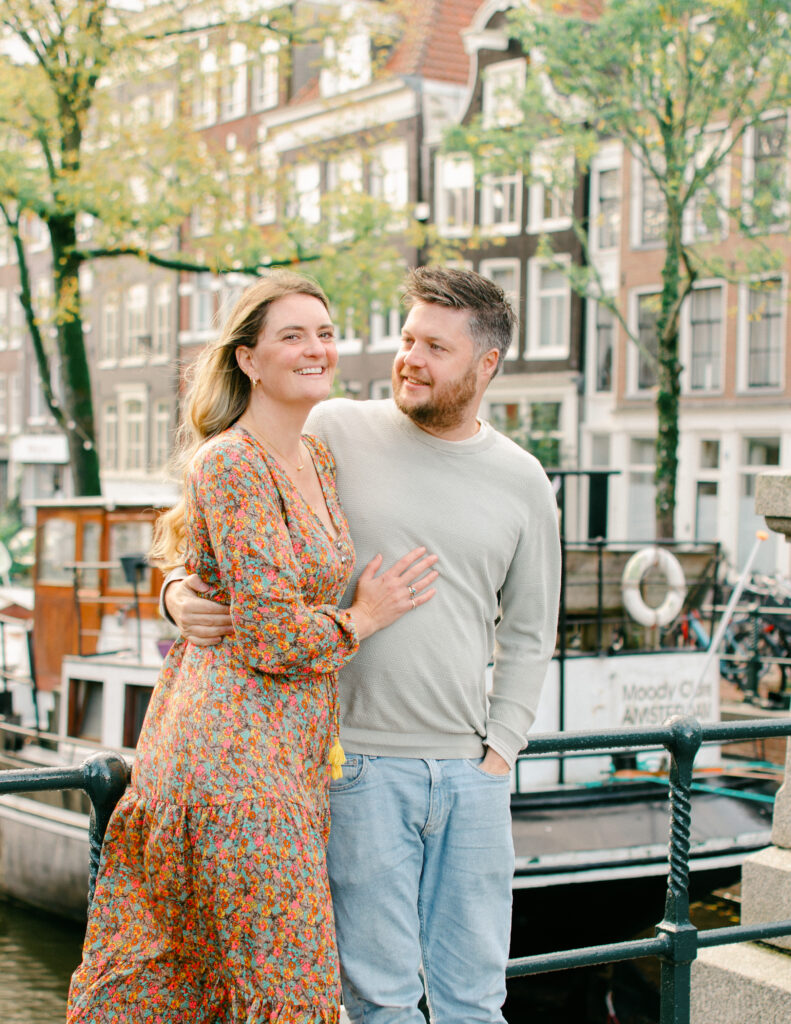 Couple embraces watching their son play during a photo session.