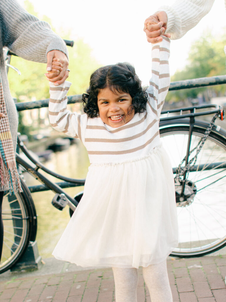 Fun and candid family photo of toddler giggling on an Amsterdam canal.