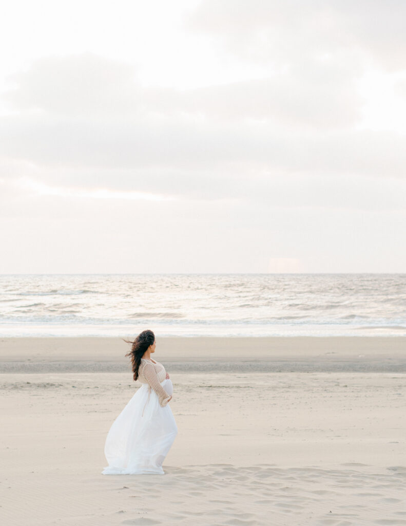 Composition shot of an expecting mama on the beach in white.