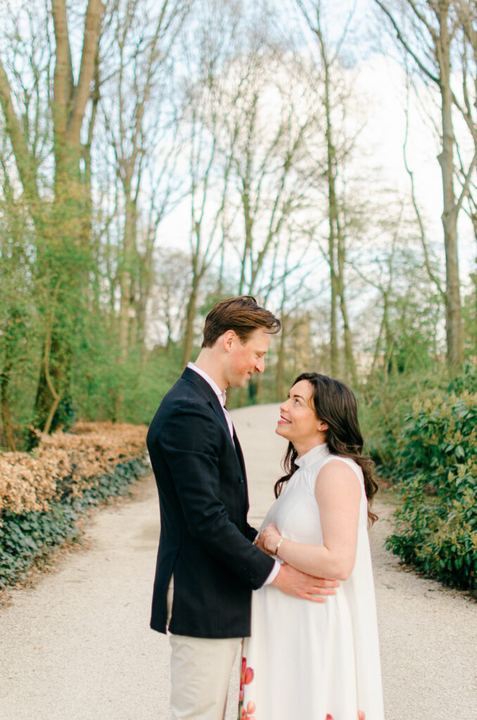 Expecting parents smile at each other in Erasmuspark.