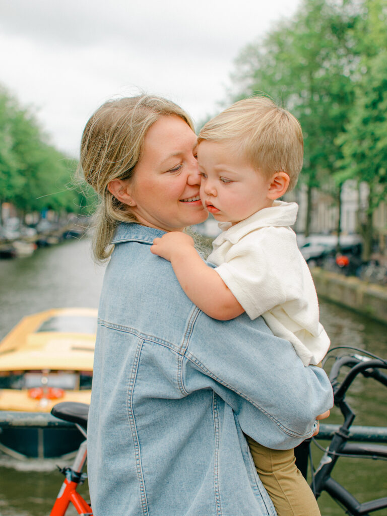 Mum snuggles toddler son on a cloudy morning in Amsterdam.