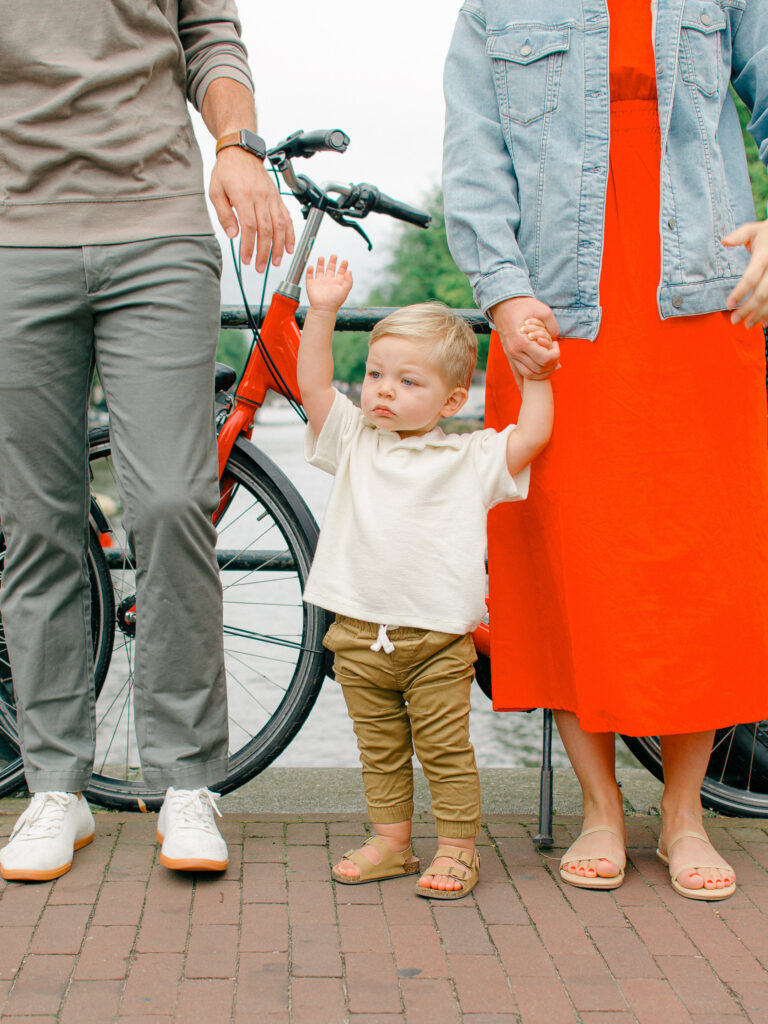Toddler boy reaches out to hold his father's hand.