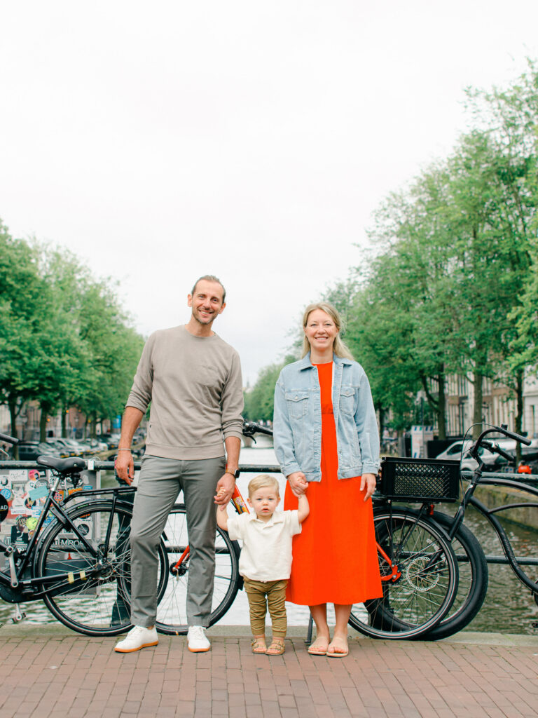 Parents swing their toddler along an Amsterdam canal.