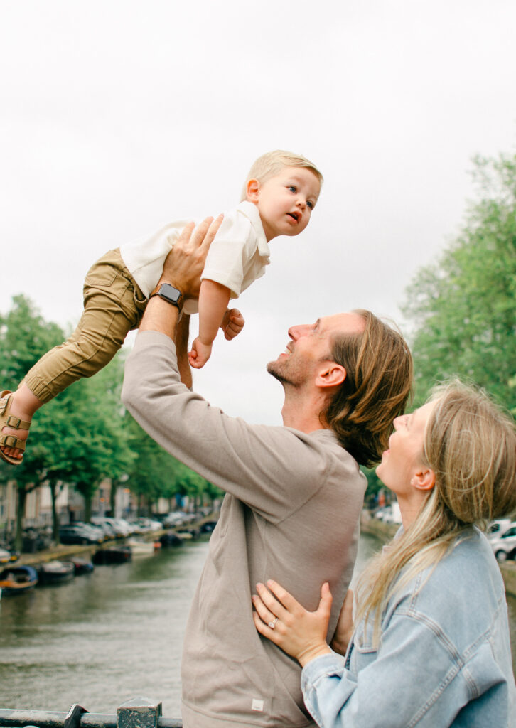 Parents throw toddler son up in the air over a canal in Amsterdam.