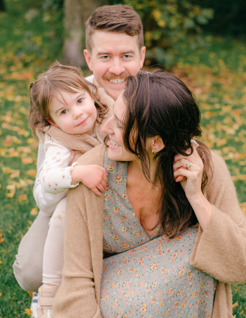Family cuddles together during a fall session.