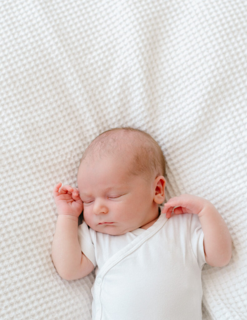 Timeless, fine art newborn image with soft white tones.