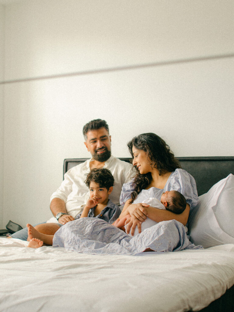 Lifestyle photo of a family cuddled up on the bed, taken from the mirror.