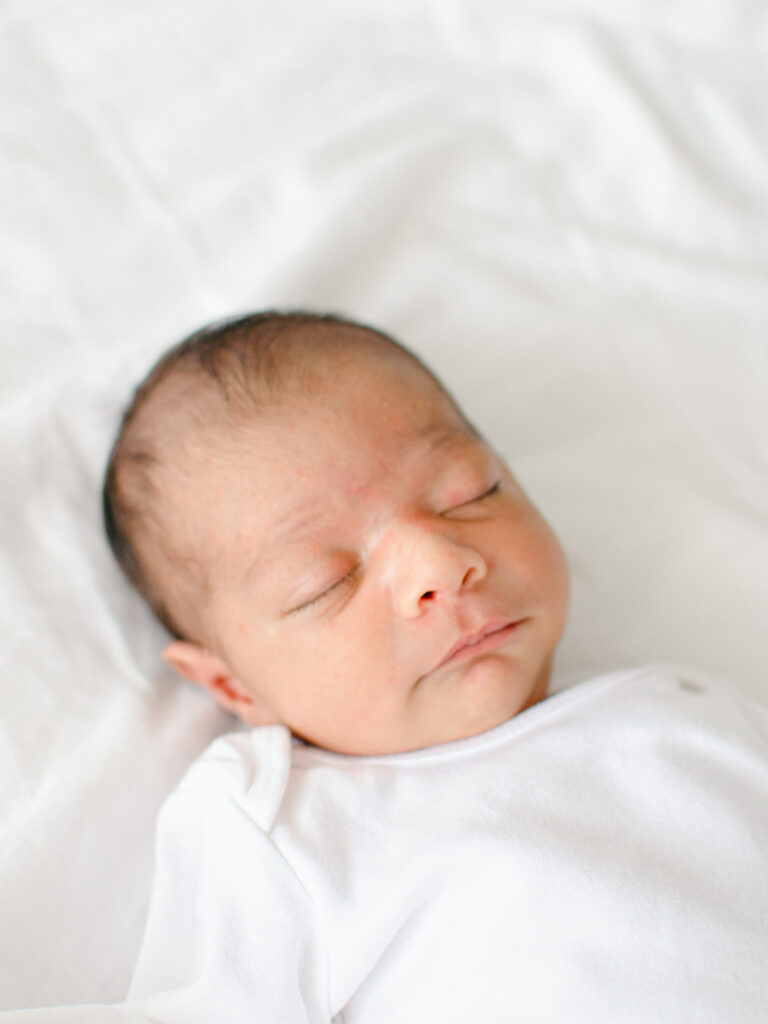Soft focus portrait of sleeping baby on parents' bed.