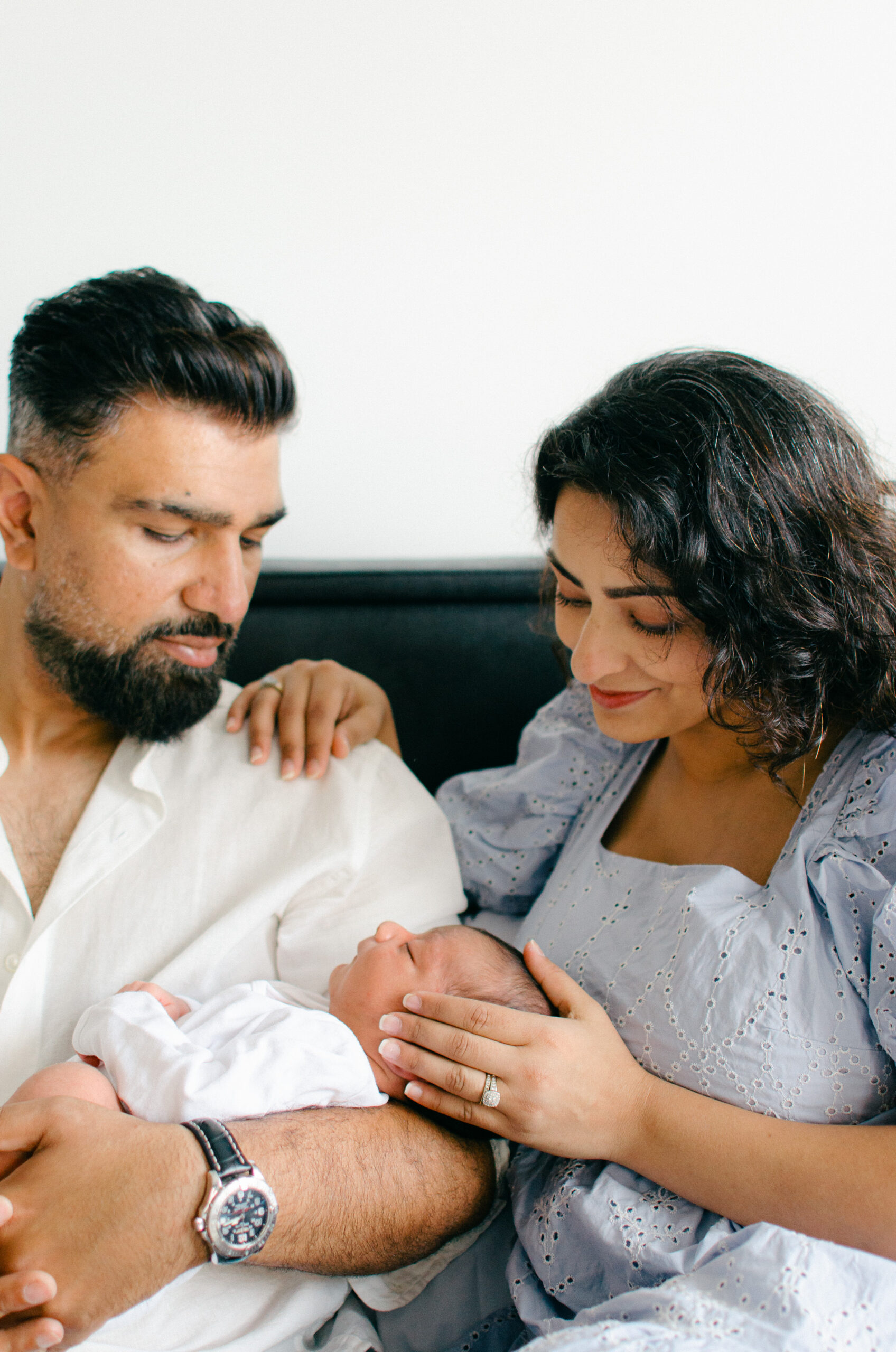 parents gaze lovingly at newborn baby during a lifestyle home shoot