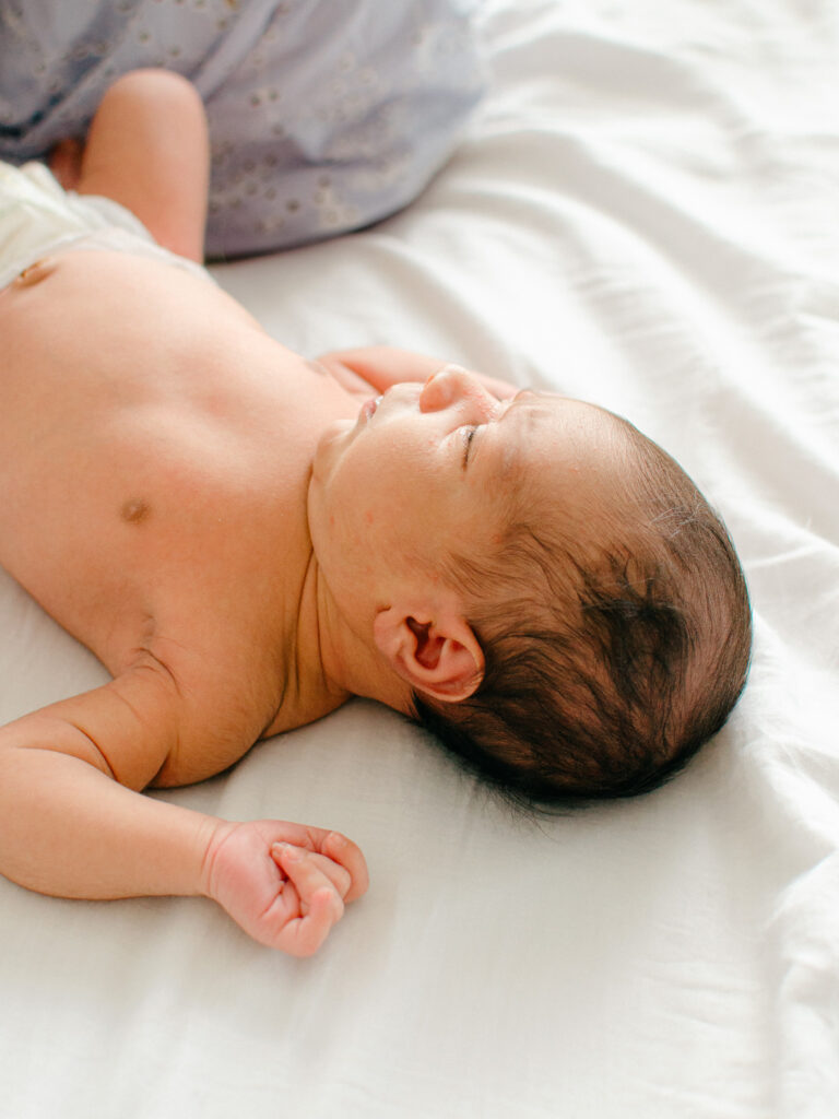 Baby rests peacefully on his parents' bed during an in-home photoshoot in Diemen.