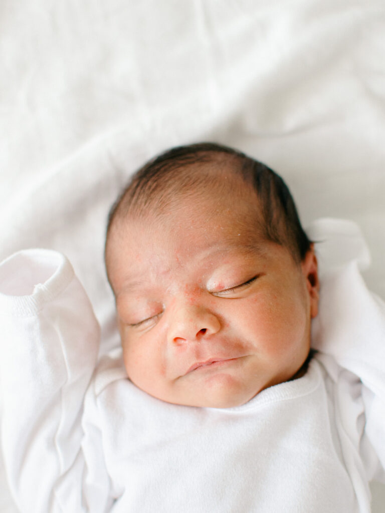 Baby smiles in his sleep during an in-home shoot.