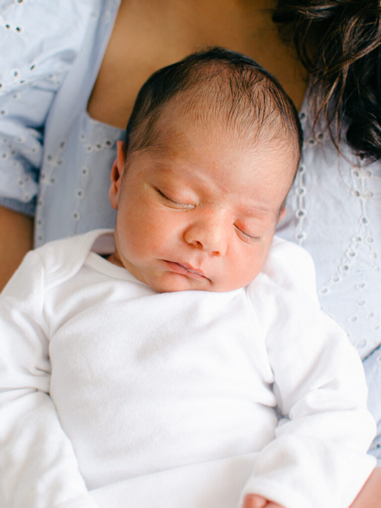 Baby sleeping on mom's chest during a newborn home photoshoot in Diemen.