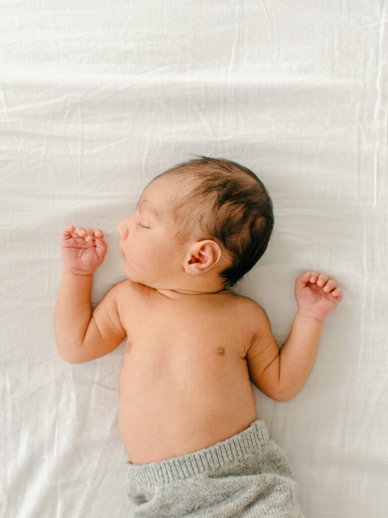Light and airy, film-inspired photo of sleeping baby on parents' bed