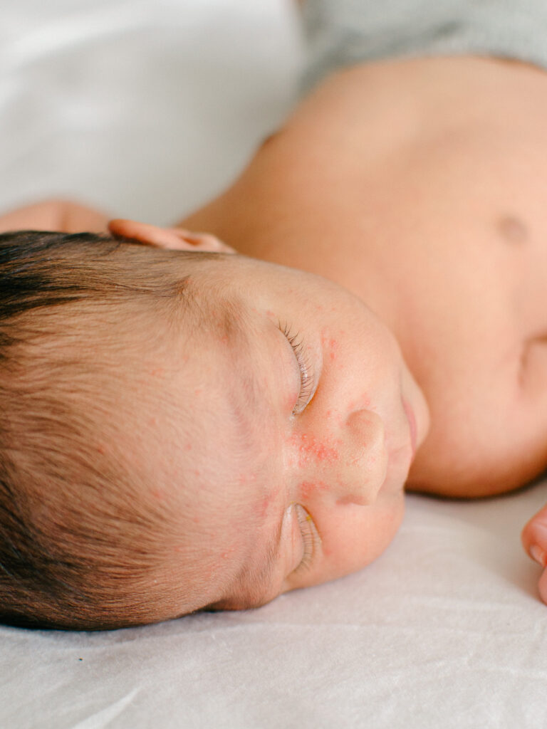 Baby is fast asleep on parents' bed during a lifestyle newborn shoot.