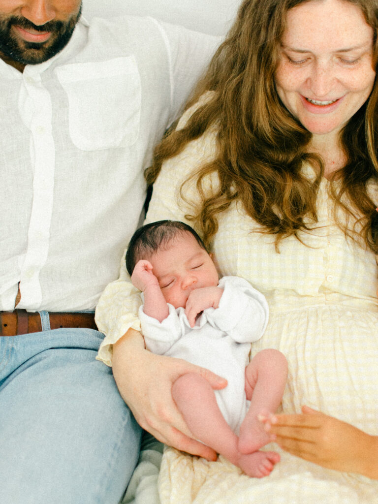 Newborn baby sleeps cradled in her mom's arms.
