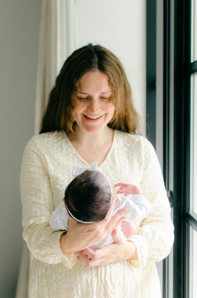 Mom gazes lovingly at her newborn daughter.