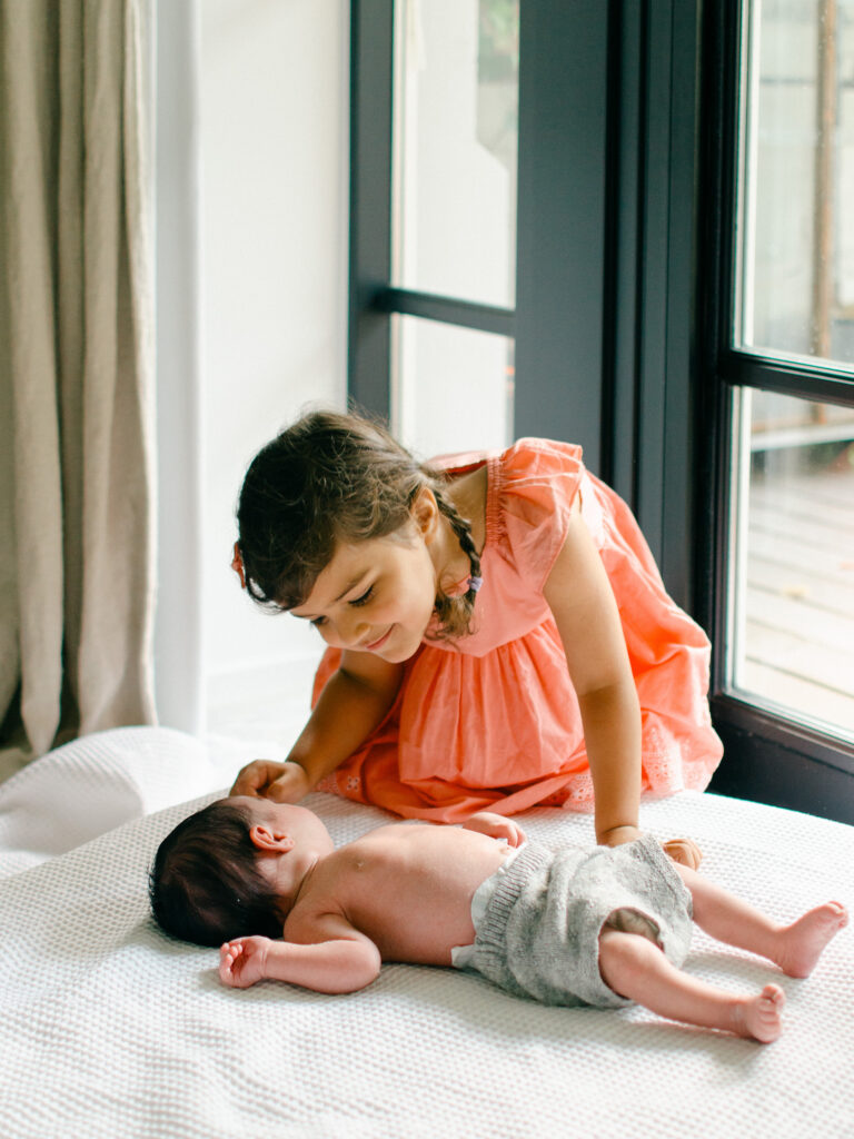 Big sister gives baby a kiss.