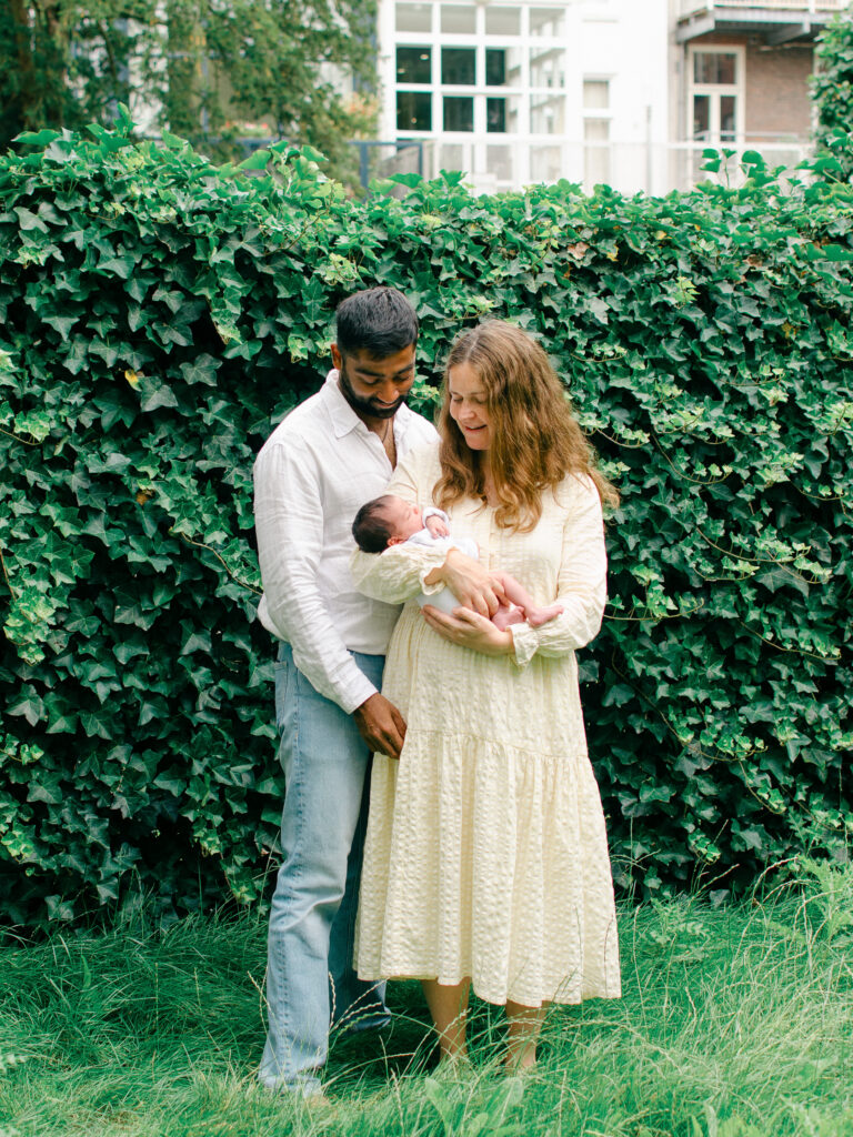 Mom and dad cradle newborn baby in their garden in Oud-West.