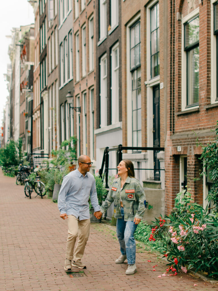 A couple skips through amsterdam in a romantic walk.