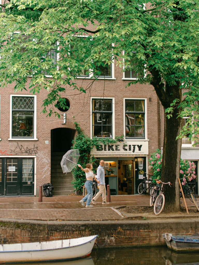 A whimsical image of a couple wandering past Bike City in Amsterdam.